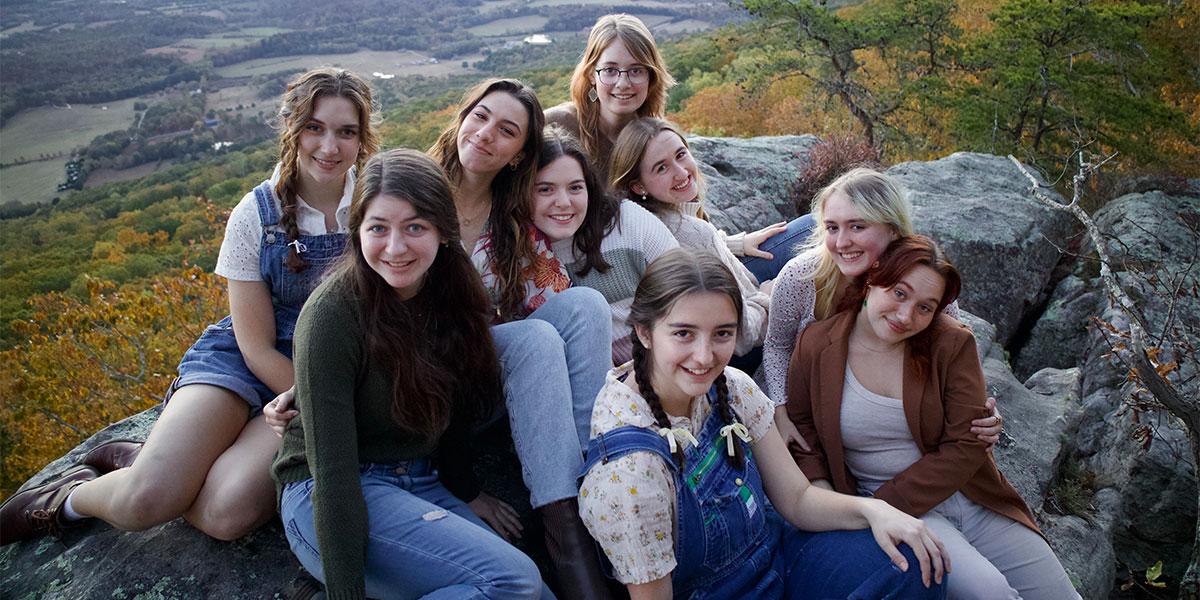 group of females sitting on a scenic overlook